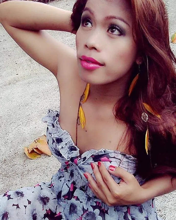 Jeune femme asiatique en sous-vêtements noirs, assise sur un canapé beige, regardant vers la caméra